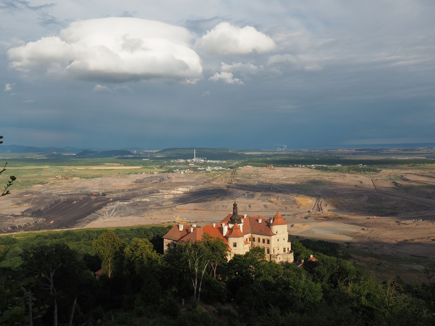 Fotografie státního zámku Jezeří a přímo za ním je lom ČSA.