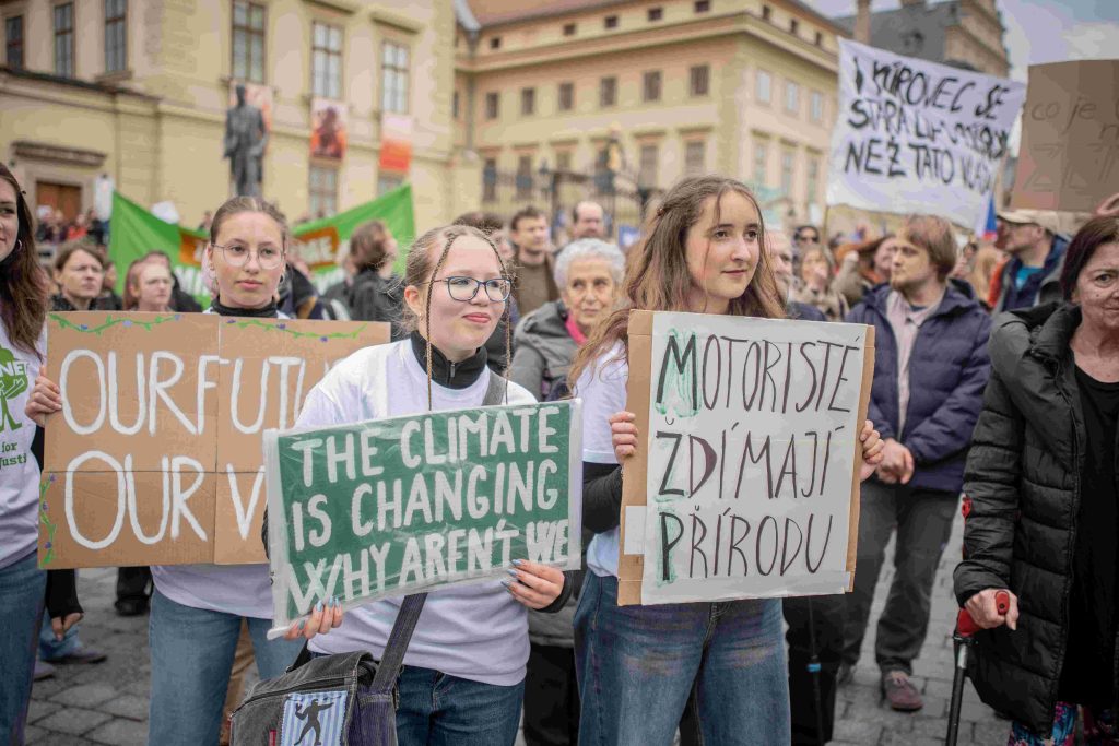 Mladí lidé drží transparenty na demonstraci za přírodu.