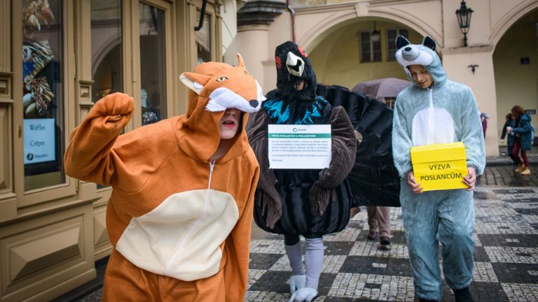 Tři lidé oblečení v kostýmech zvířat.