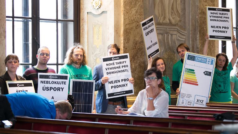 Skupina protestujících na veřejném zasedání.