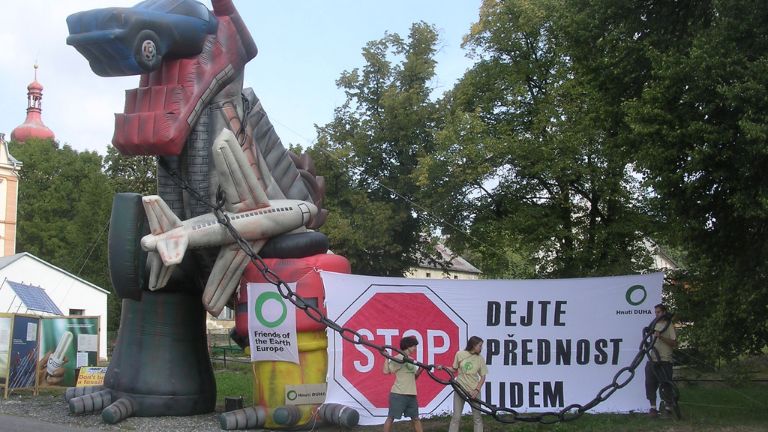 Happening s nafukovací godzillou a obrovským bannerem Dejte přednost lidem.